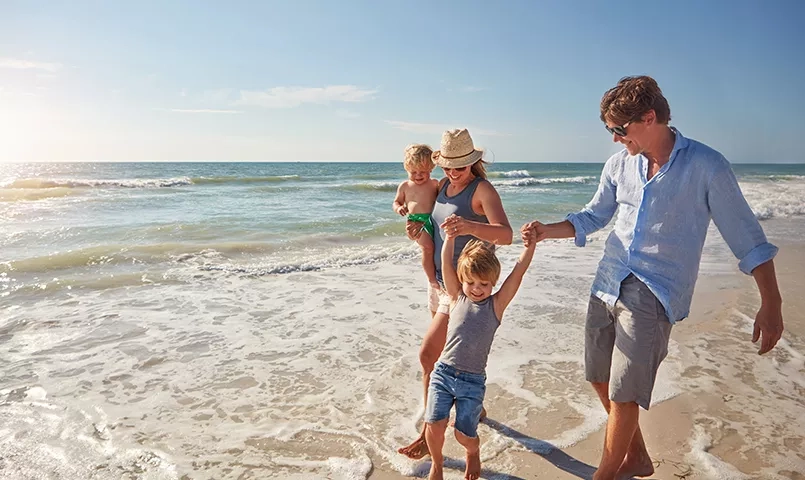 Famille avec 2 enfants se promenant sur la plage
