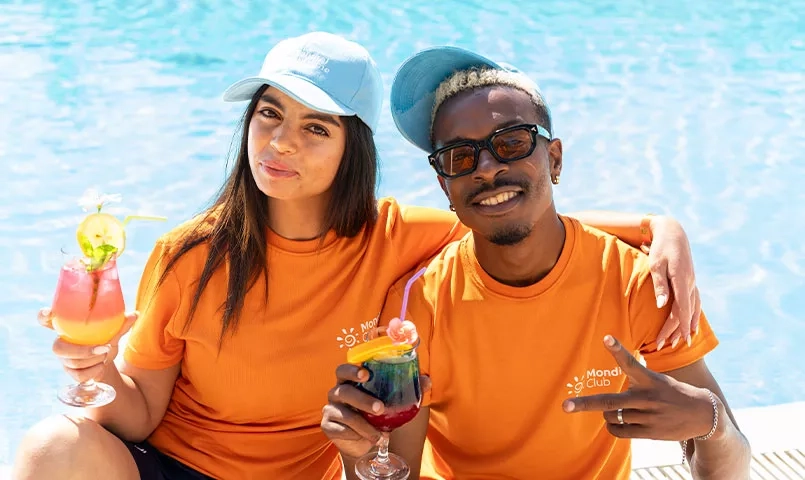 Deux animateurs souriants tenant des cocktails coloré.