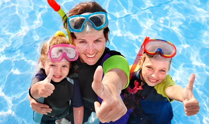 Une mère et ses deux enfants équipés pour la plongée.