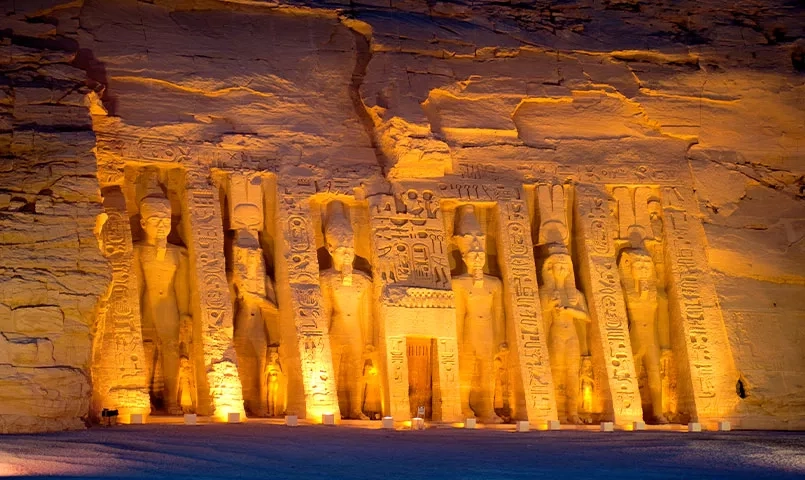Le temple d'Abou Simbel illuminé de nuit, avec ses statues colossales sculptées dans la roche. 
