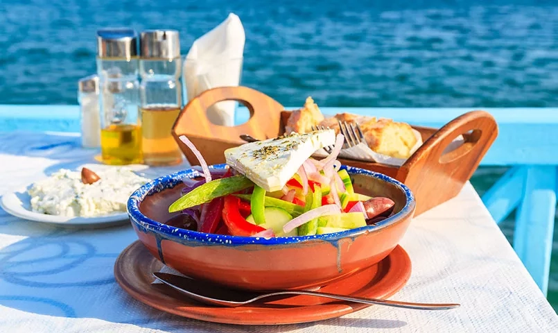 une salade grecque sur une table devant la mer