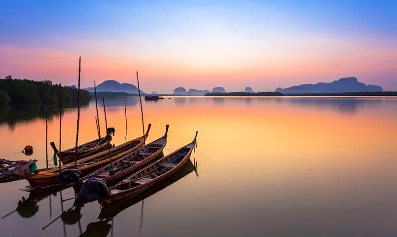 des barques thaïlandaises au lever du soleil
