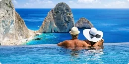 Couple dans une piscine à débordement qui regarde au loin la mer