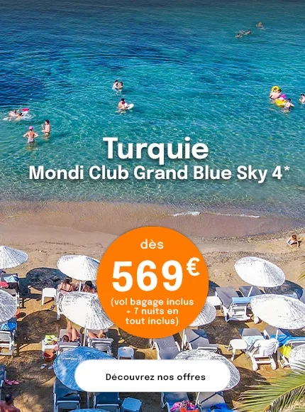 une plage avec des parasols et des gens qui se baignent dans une mer turquoise