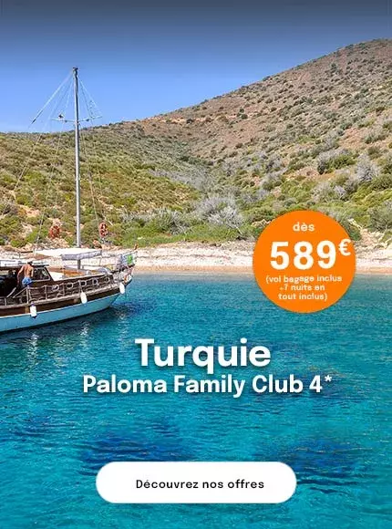 une goélette en bois avec un homme sur le pont dans une crique aux eaux turquoise pour proposer une offre dès 589€