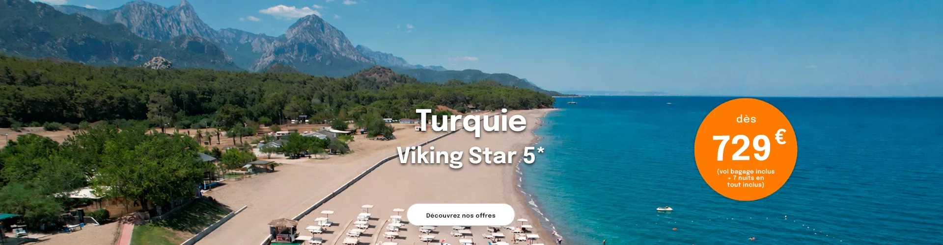 la mer en Turquie avec une plage avec des transats et la montagne en arrière plan avec une offre dès 729€