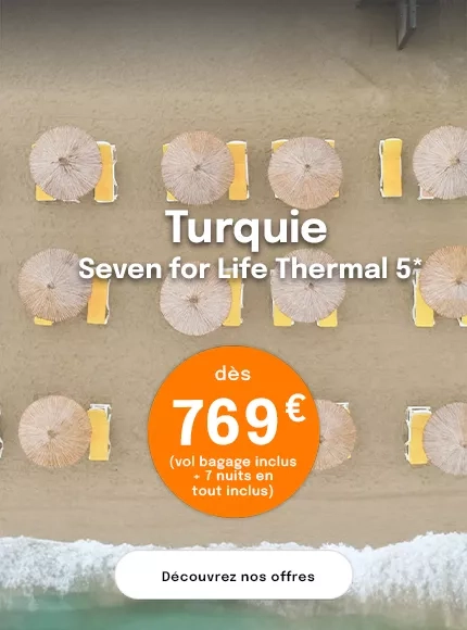 Vue de haut sur une plage avec des parasols et des transats jaunes