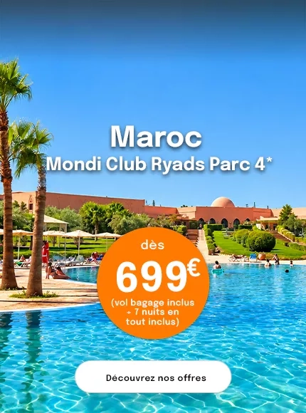 une piscine avec un hôtel ocre au fond