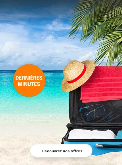 une valise ouverte sur la plage avec des vêtements de vacances