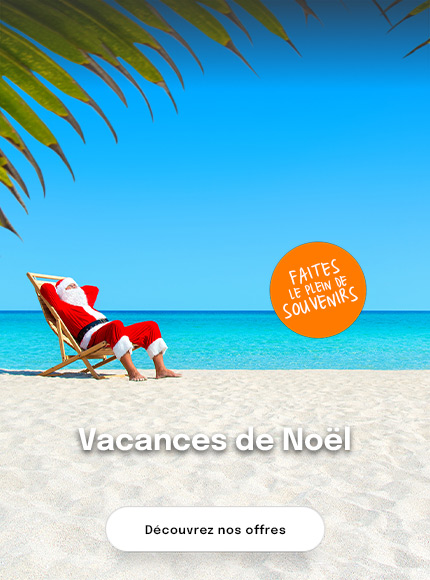 Père noël sur un transat à la plage