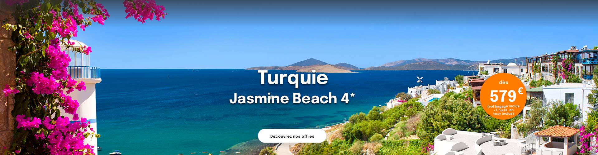 un village de maisons blanches surplombant la mer Egee en Turquie et des bougainvilliers roses en premier plan